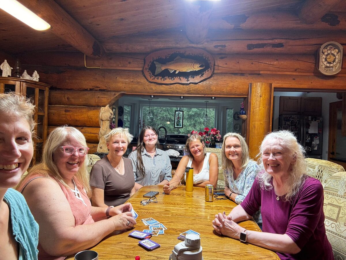 Gathered around a log cabin dining table playing cards at Sherry Gates' birthday party, Alaska