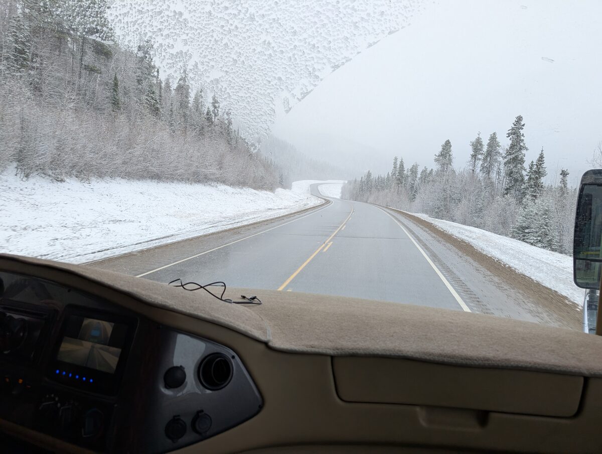 Snowy Alaska Highway in April viewed from Class A motorhome windshield