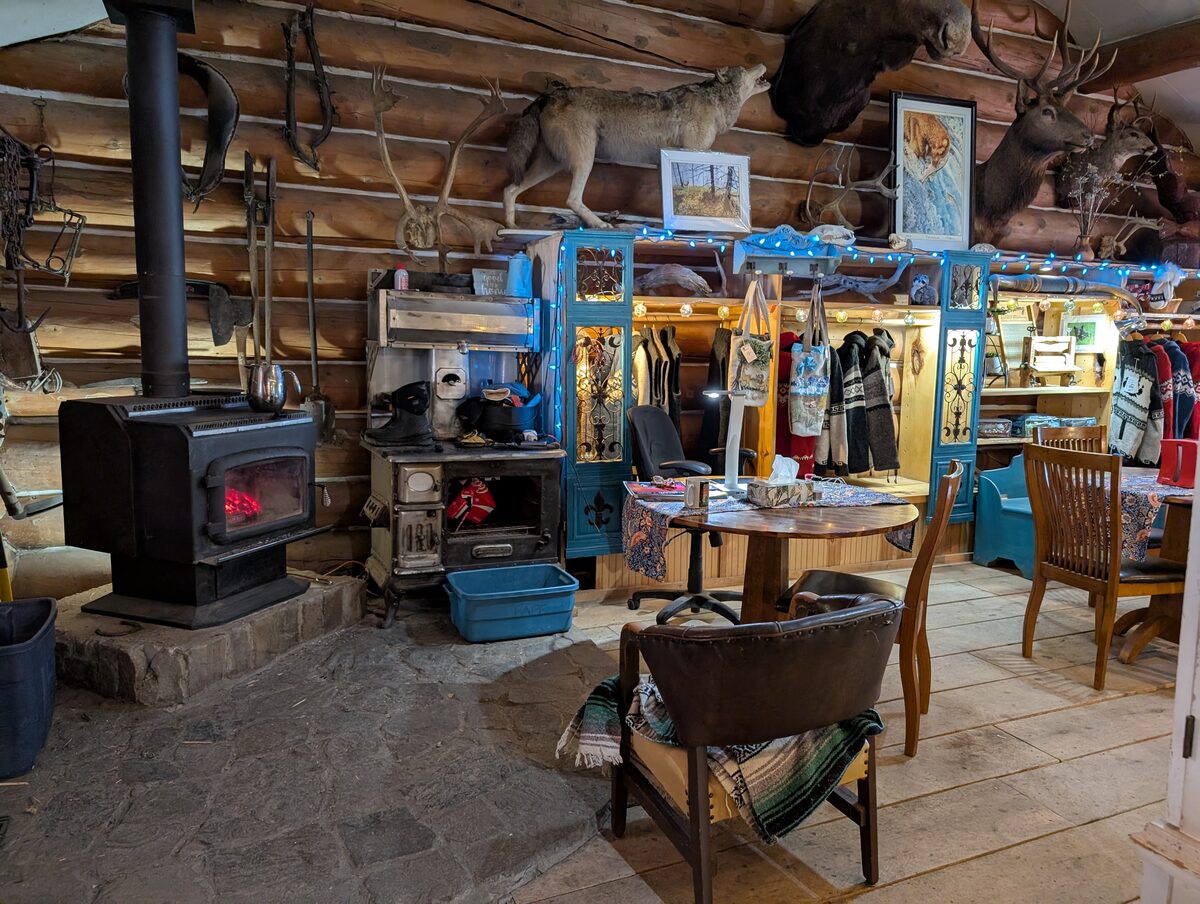Rustic interior of Tetsa River Lodge with wood stove and taxidermy on Alaska Highway