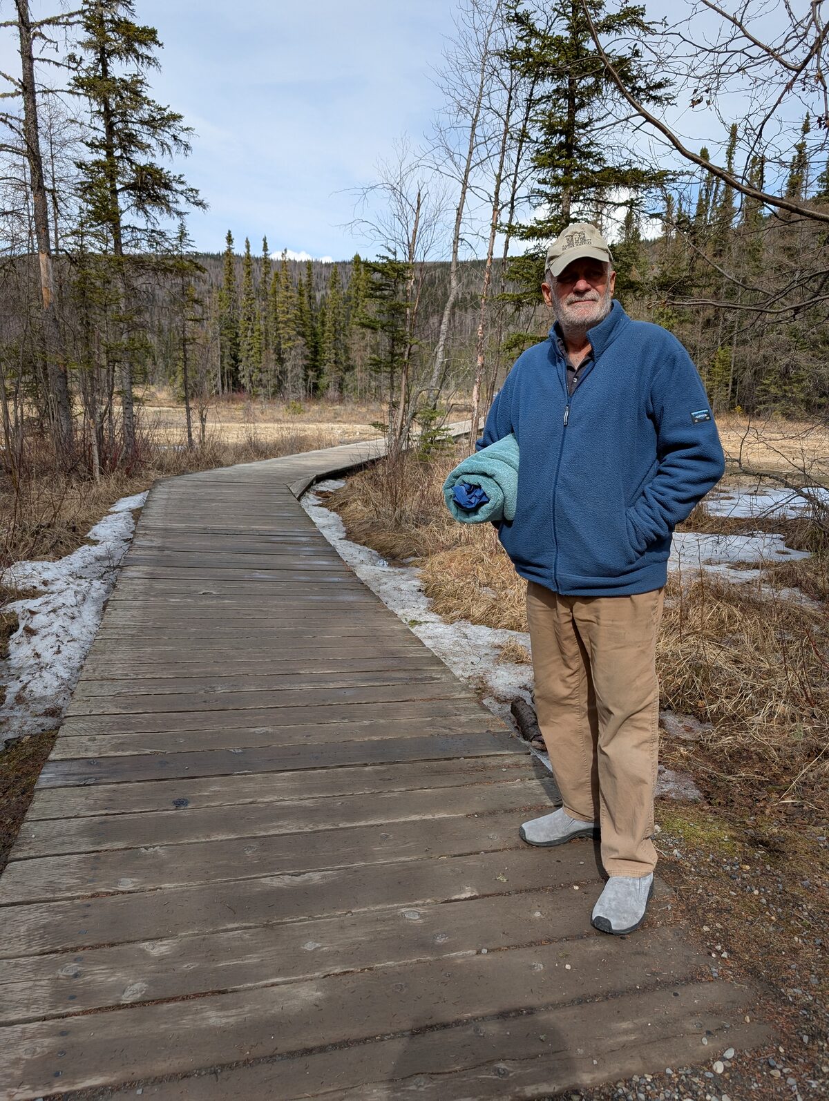 Mike on the boardwalk trail to Liard Hot Springs with towel in hand