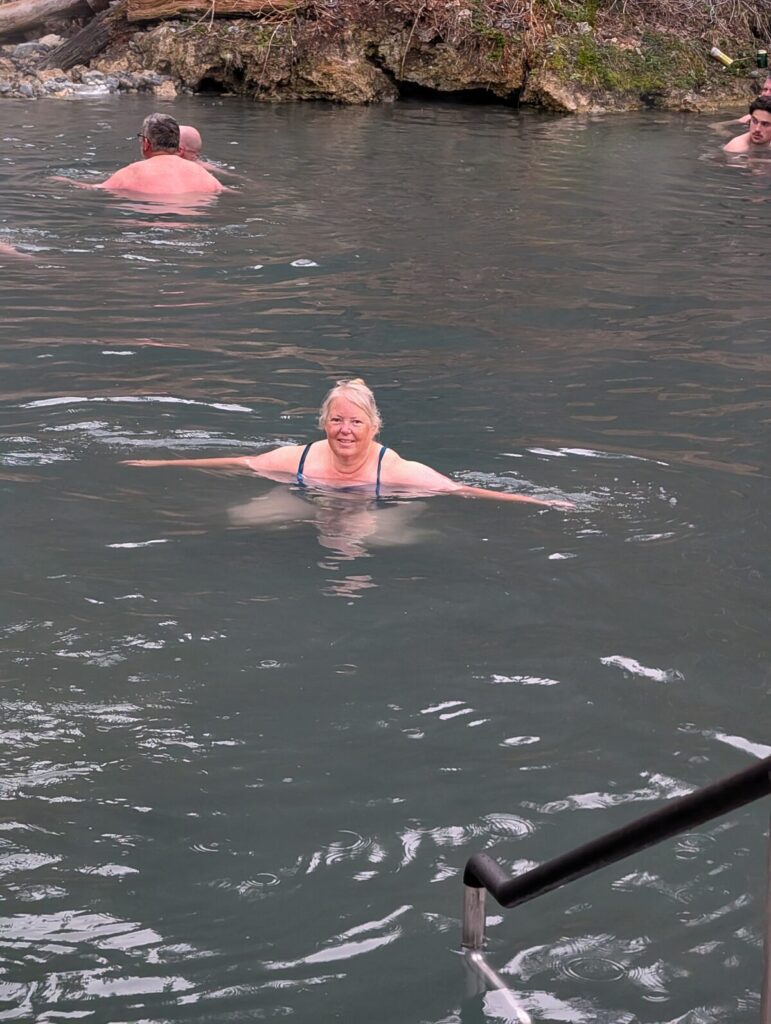Phyllis swimming in the natural hot springs pool at Liard River BC