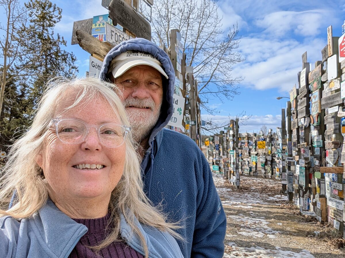 Phyllis and Mike selfie at Watson Lake Sign Post Forest Yukon Canada