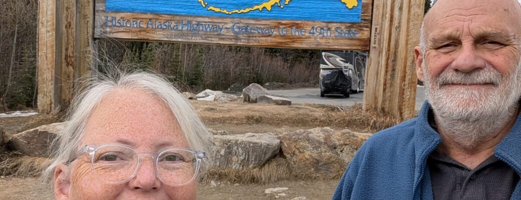 Phyllis and Mike at the Welcome to Alaska sign on the Historic Alaska Highway