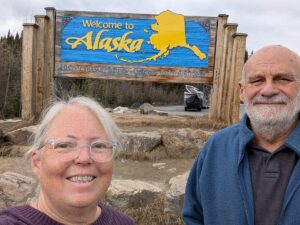 Phyllis and Mike at the Welcome to Alaska sign on the Historic Alaska Highway
