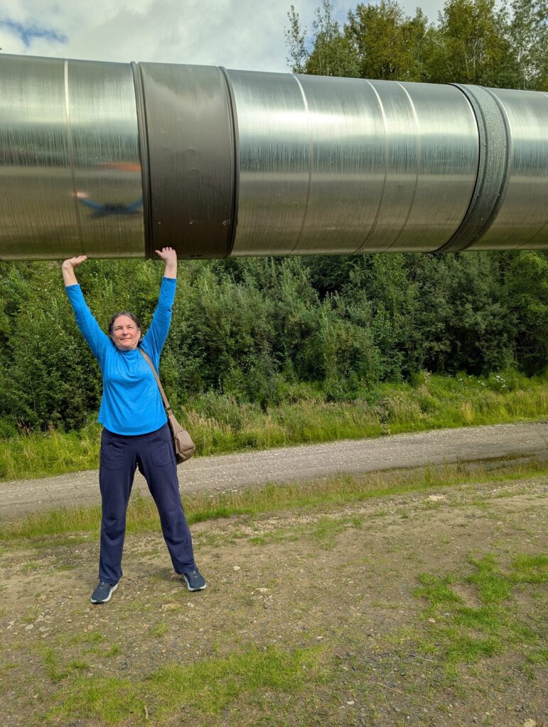 Vicky holding up the Trans-Alaska Pipeline near Fairbanks
