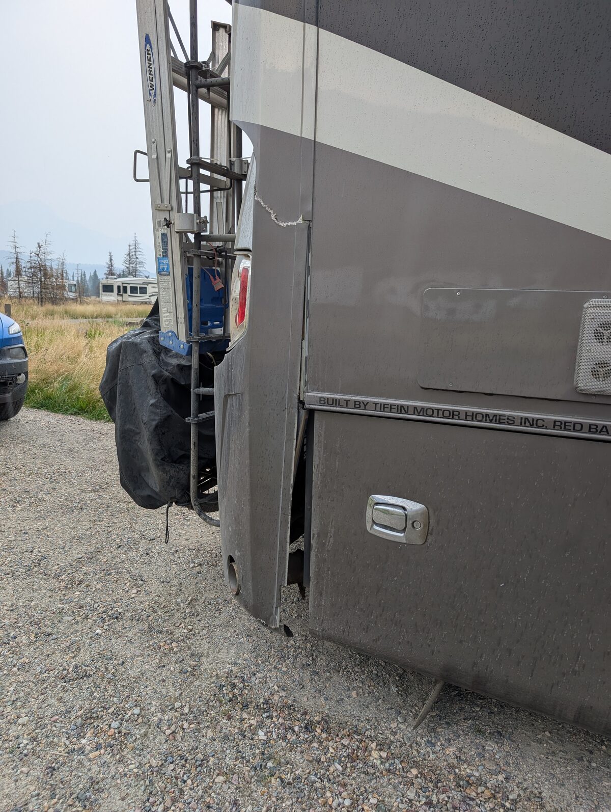 Cracked rear fiberglass cap on the Tiffin RV after hitting a steep slope at a Harvest Host in Canada