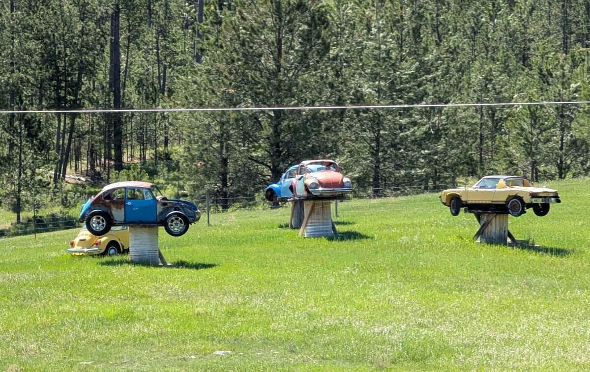 A roadside oddity along the way — vintage VWs (and a Porsche) mounted on posts